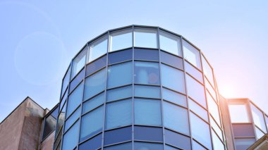 Yansıtıcı levhalar ve camlarla kaplı modern bir apartmanın dış cephesinin soyut görüntüsü..