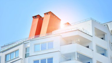 Geniş pencereli bir apartmanın modern beyaz cephesi. Modern tasarlanmış beton apartman manzarası.