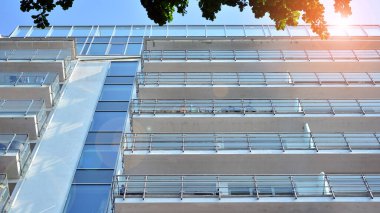 Cam balkonlu yeni apartman. Deniz kenarındaki modern mimari evler. Binanın ön cephesinde büyük camlar var..