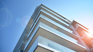 Cam balkonlu yeni apartman. Deniz kenarındaki modern mimari evler. Binanın ön cephesinde büyük camlar var..