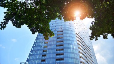 Cam ve çelik. Günümüz ofis binasının aynalı yüzü. Güneş ışınları yansıtıyor.