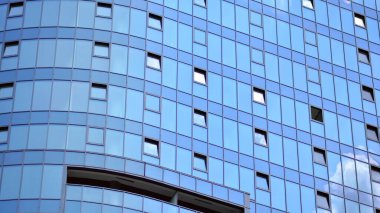 Cam ve çelik. Mavi gökyüzü olan modern ofis binasının aynalı yüzü..