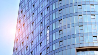 Cam ve çelik. Günümüz ofis binasının aynalı yüzü. Güneş ışınları yansıtıyor.