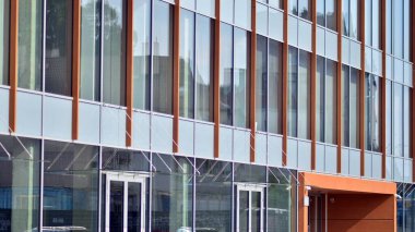 Camla kaplı modern bir ofis binasının gelecekteki dış görünüşü. Modern binanın cam kaplama panelleri ve pencereleri. Geometri ve perspektifli bir ofis binası.