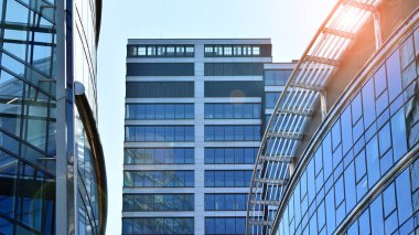 Mavi gökyüzünün altında cam duvarlı ofis manzarası. İş geçmişinin mimari ayrıntıları.