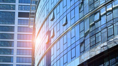 Mavi gökyüzünün altında cam duvarlı ofis manzarası. İş geçmişinin mimari ayrıntıları.