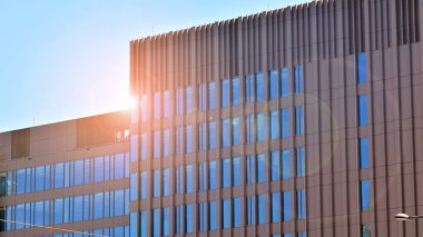 Mavi gökyüzünün altında cam duvarlı ofis manzarası. İş geçmişinin mimari ayrıntıları.