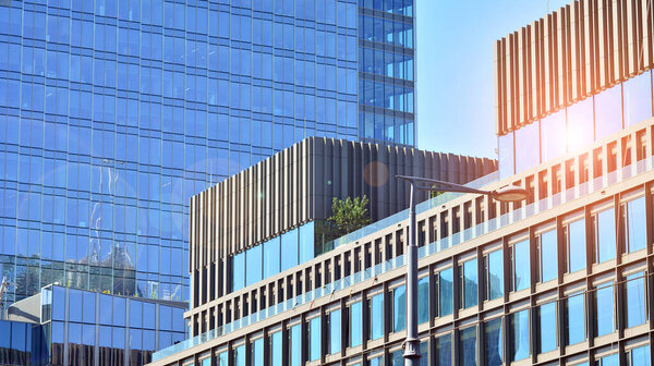 View of office building with glass wall under blue sky. Architecture details of business background.