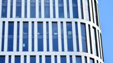 Mavi gökyüzünde beyaz duvarları olan modern ofis binası