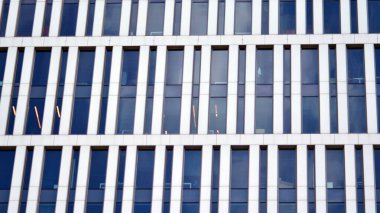 Mavi gökyüzünde beyaz duvarları olan modern ofis binası