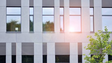 Mavi gökyüzünde beyaz duvarları olan modern ofis binası.