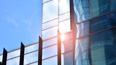 Pencerelerde mavi gökyüzünü yansıtan cam ofis binasının güzel bir arka planı..