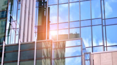 Pencerelerde mavi gökyüzünü yansıtan cam ofis binasının güzel bir arka planı..