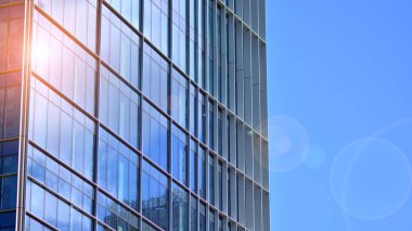  Cam aynalı ofis binasının ön dokusu. Ön cephenin bir parçası. Günbatımında akşam ışığında mercek filtre efektiyle modern gökdelenlerin en alt görüntüsü.