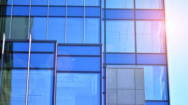  Cam aynalı ofis binasının ön dokusu. Ön cephenin bir parçası. Günbatımında akşam ışığında mercek filtre efektiyle modern gökdelenlerin en alt görüntüsü.