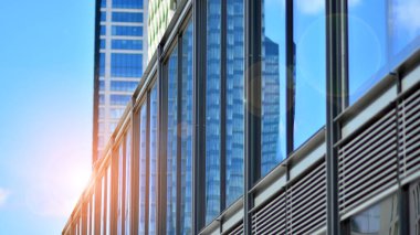  Cam aynalı ofis binasının ön dokusu. Ön cephenin bir parçası. Günbatımında akşam ışığında mercek filtre efektiyle modern gökdelenlerin en alt görüntüsü.