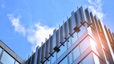  Cam aynalı ofis binasının ön dokusu. Ön cephenin bir parçası. Günbatımında akşam ışığında mercek filtre efektiyle modern gökdelenlerin en alt görüntüsü.