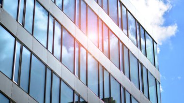  Cam aynalı ofis binasının ön dokusu. Ön cephenin bir parçası. Günbatımında akşam ışığında mercek filtre efektiyle modern gökdelenlerin en alt görüntüsü.