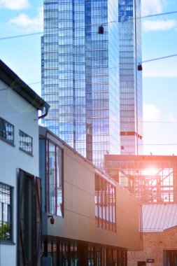  Cam aynalı ofis binasının ön dokusu. Ön cephenin bir parçası. Günbatımında akşam ışığında mercek filtre efektiyle modern gökdelenlerin en alt görüntüsü.