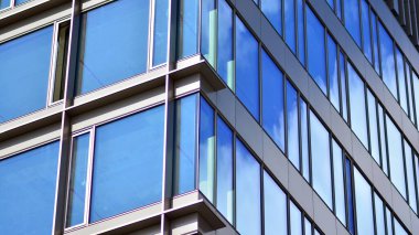  Cam aynalı ofis binasının ön dokusu. Ön cephenin bir parçası. Günbatımında akşam ışığında mercek filtre efektiyle modern gökdelenlerin en alt görüntüsü.