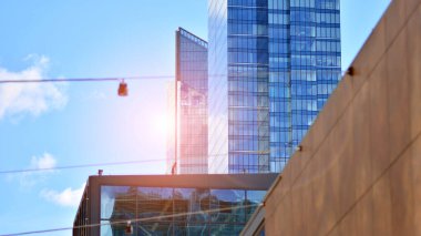  Cam aynalı ofis binasının ön dokusu. Ön cephenin bir parçası. Günbatımında akşam ışığında mercek filtre efektiyle modern gökdelenlerin en alt görüntüsü.