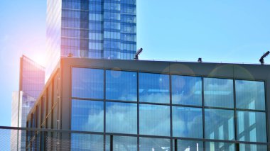 Cam aynalı ofis binasının ön dokusu. Ön cephenin bir parçası. Günbatımında akşam ışığında mercek filtre efektiyle modern gökdelenlerin en alt görüntüsü.