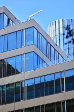  Cam aynalı ofis binasının ön dokusu. Ön cephenin bir parçası. Günbatımında akşam ışığında mercek filtre efektiyle modern gökdelenlerin en alt görüntüsü.