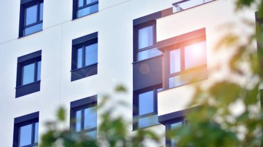 Ekolojik konut mimarisi. Ağaçların çevresindeki modern bir yerleşim yeri. Ekoloji ve yeşil yaşam şehirde, kentsel çevre kavramı. Modern apartman ve yeşil ağaçlar.