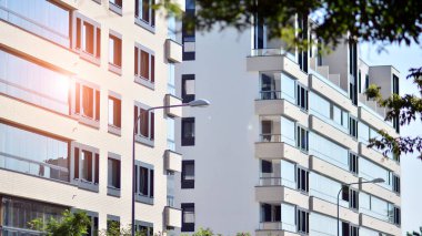 Ekolojik konut mimarisi. Ağaçların çevresindeki modern bir yerleşim yeri. Ekoloji ve yeşil yaşam şehirde, kentsel çevre kavramı. Modern apartman ve yeşil ağaçlar.