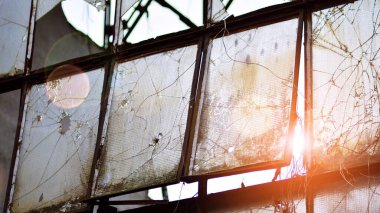 Terk edilmiş ve sanayi fabrikası yok edilmiş. Ufukta kızıl güneş, Bokeh güneş patlaması.