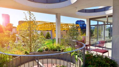 Modern luxury office building.The structure features a glass and concrete walls, showcasing contemporary architecture. The green surroundings of office buildings. Trees and shrubs in the city.
