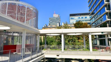 Modern luxury office building.The structure features a glass and concrete walls, showcasing contemporary architecture. The green surroundings of office buildings. Trees and shrubs in the city.