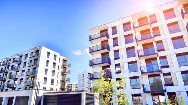 Bereketli yeşil ağaçlarla çevrili ve güneşli bir günde taze bitki örtüsüyle çevrili bir yerleşim yeri. Çağdaş mimari konut kompleksi yeşilliklerle çevrili.