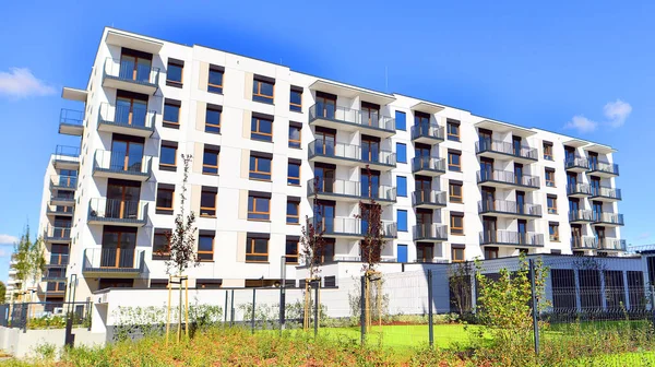 Bereketli yeşil ağaçlarla çevrili ve güneşli bir günde taze bitki örtüsüyle çevrili bir yerleşim yeri. Çağdaş mimari konut kompleksi yeşilliklerle çevrili.