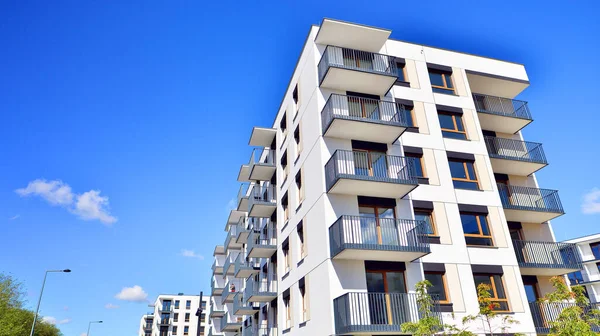 Bereketli yeşil ağaçlarla çevrili ve güneşli bir günde taze bitki örtüsüyle çevrili bir yerleşim yeri. Çağdaş mimari konut kompleksi yeşilliklerle çevrili.