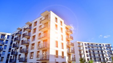 Bereketli yeşil ağaçlarla çevrili ve güneşli bir günde taze bitki örtüsüyle çevrili bir yerleşim yeri. Çağdaş mimari konut kompleksi yeşilliklerle çevrili.