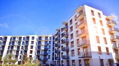 Bereketli yeşil ağaçlarla çevrili ve güneşli bir günde taze bitki örtüsüyle çevrili bir yerleşim yeri. Çağdaş mimari konut kompleksi yeşilliklerle çevrili.