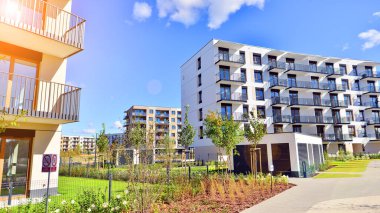 Bereketli yeşil ağaçlarla çevrili ve güneşli bir günde taze bitki örtüsüyle çevrili bir yerleşim yeri. Çağdaş mimari konut kompleksi yeşilliklerle çevrili.