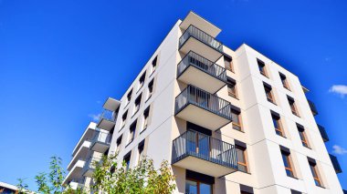 Bereketli yeşil ağaçlarla çevrili ve güneşli bir günde taze bitki örtüsüyle çevrili bir yerleşim yeri. Çağdaş mimari konut kompleksi yeşilliklerle çevrili.