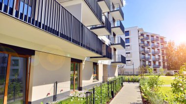 Bereketli yeşil ağaçlarla çevrili ve güneşli bir günde taze bitki örtüsüyle çevrili bir yerleşim yeri. Çağdaş mimari konut kompleksi yeşilliklerle çevrili.