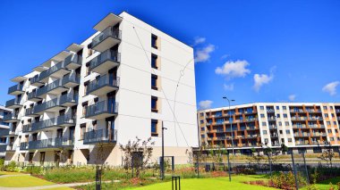 Bereketli yeşil ağaçlarla çevrili ve güneşli bir günde taze bitki örtüsüyle çevrili bir yerleşim yeri. Çağdaş mimari konut kompleksi yeşilliklerle çevrili.