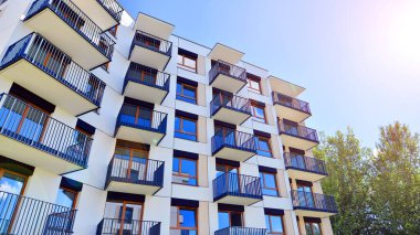 Bereketli yeşil ağaçlarla çevrili ve güneşli bir günde taze bitki örtüsüyle çevrili bir yerleşim yeri. Çağdaş mimari konut kompleksi yeşilliklerle çevrili.