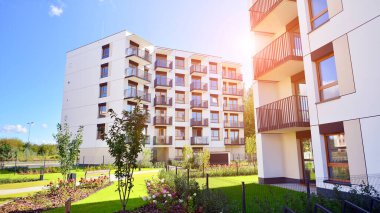 Bereketli yeşil ağaçlarla çevrili ve güneşli bir günde taze bitki örtüsüyle çevrili bir yerleşim yeri. Çağdaş mimari konut kompleksi yeşilliklerle çevrili.