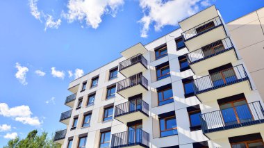 Bereketli yeşil ağaçlarla çevrili ve güneşli bir günde taze bitki örtüsüyle çevrili bir yerleşim yeri. Çağdaş mimari konut kompleksi yeşilliklerle çevrili.