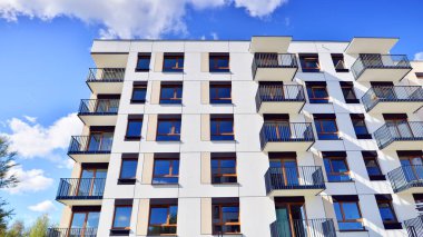 Bereketli yeşil ağaçlarla çevrili ve güneşli bir günde taze bitki örtüsüyle çevrili bir yerleşim yeri. Çağdaş mimari konut kompleksi yeşilliklerle çevrili.