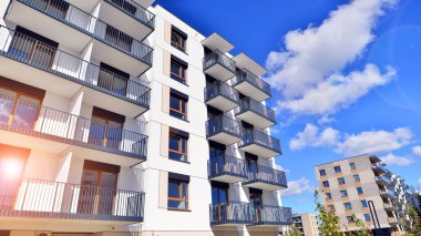 Bereketli yeşil ağaçlarla çevrili ve güneşli bir günde taze bitki örtüsüyle çevrili bir yerleşim yeri. Çağdaş mimari konut kompleksi yeşilliklerle çevrili.