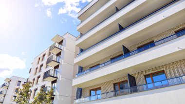 Bereketli yeşil ağaçlarla çevrili ve güneşli bir günde taze bitki örtüsüyle çevrili bir yerleşim yeri. Çağdaş mimari konut kompleksi yeşilliklerle çevrili.