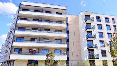 Bereketli yeşil ağaçlarla çevrili ve güneşli bir günde taze bitki örtüsüyle çevrili bir yerleşim yeri. Çağdaş mimari konut kompleksi yeşilliklerle çevrili.