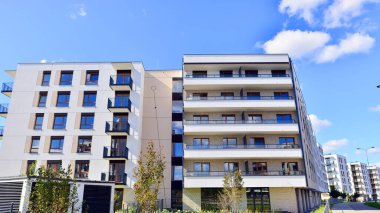 Bereketli yeşil ağaçlarla çevrili ve güneşli bir günde taze bitki örtüsüyle çevrili bir yerleşim yeri. Çağdaş mimari konut kompleksi yeşilliklerle çevrili.