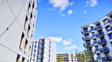 Bereketli yeşil ağaçlarla çevrili ve güneşli bir günde taze bitki örtüsüyle çevrili bir yerleşim yeri. Çağdaş mimari konut kompleksi yeşilliklerle çevrili.